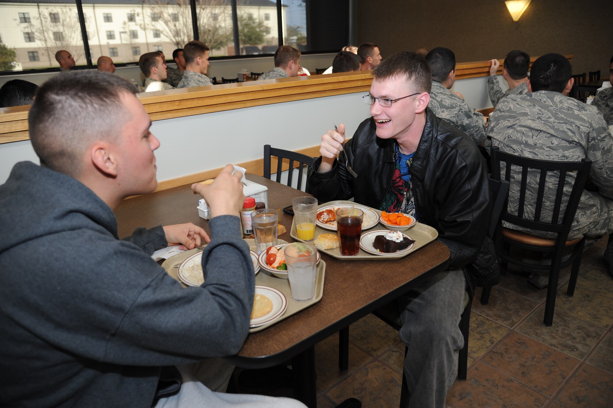 Airman 1st Class Ricardo Hernandez and Airman Basic James DeCoster, 338th Training Squadron, eat lunch at the Azalea Dining Facility Jan. 22, 2013, at Keesler Air Force Base, Miss.  The 81st Force Support Squadron food service operations accommodated a $1.25 million budget cut by shortening hours at the Live Oak Dining facility and expanding hours at Azalea and Magnolia dining halls.  (U.S. Air Force photo by Kemberly Groue)