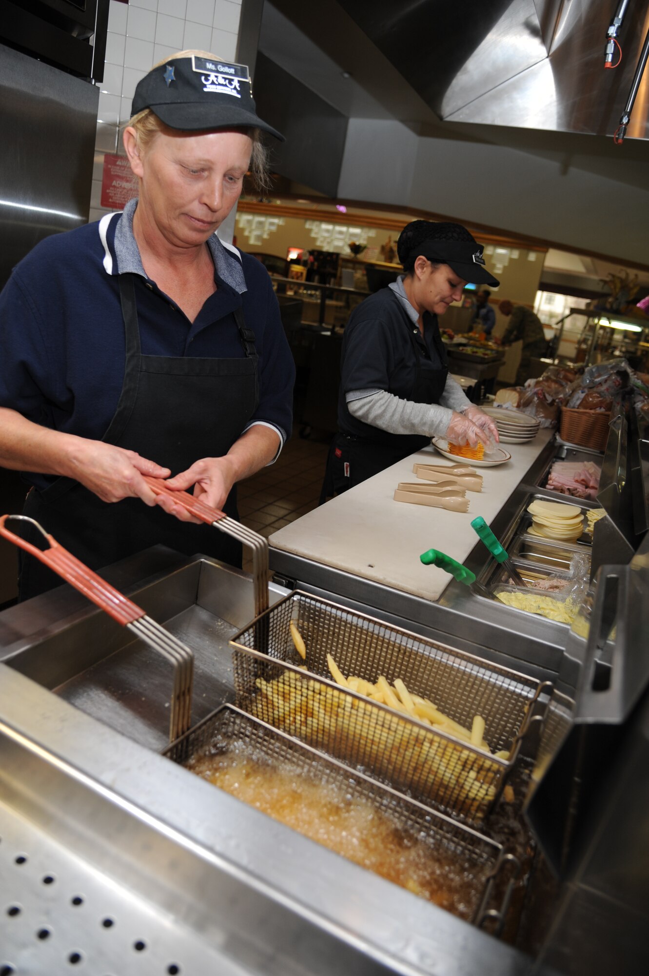 Line servers Denise Gollott and Tina Gulisao prepare food on the sandwich line at the Azalea Dining Facility Jan. 22, 2013, at Keesler Air Force Base, Miss.  The 81st Force Support Squadron food service operations accommodated a $1.25 million budget cut by shortening hours at the Live Oak Dining facility and expanding hours at Azalea and Magnolia dining halls.  (U.S. Air Force photo by Kemberly Groue)