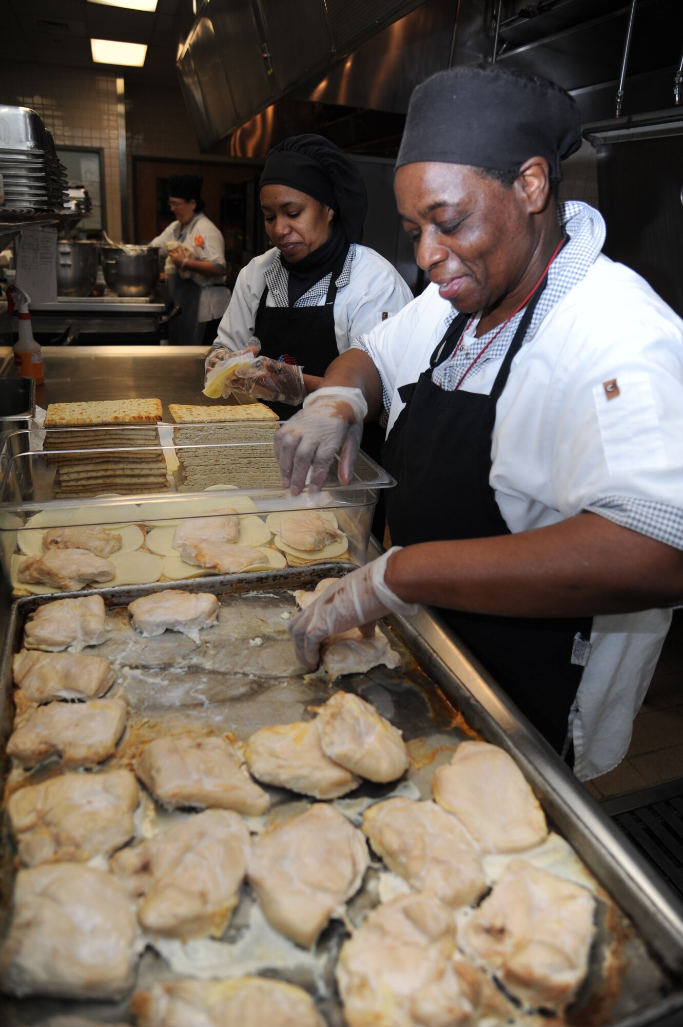 Kit Bumpus and Grace Jones, cooks, prepare el pollo pesto sandwiches at the Azalea Dining Facility Jan. 22, 2013, at Keesler Air Force Base, Miss.  The 81st Force Support Squadron food service operations accommodated a $1.25 million budget cut by shortening hours at the Live Oak Dining facility and expanding hours at Azalea and Magnolia dining halls.  (U.S. Air Force photo by Kemberly Groue)