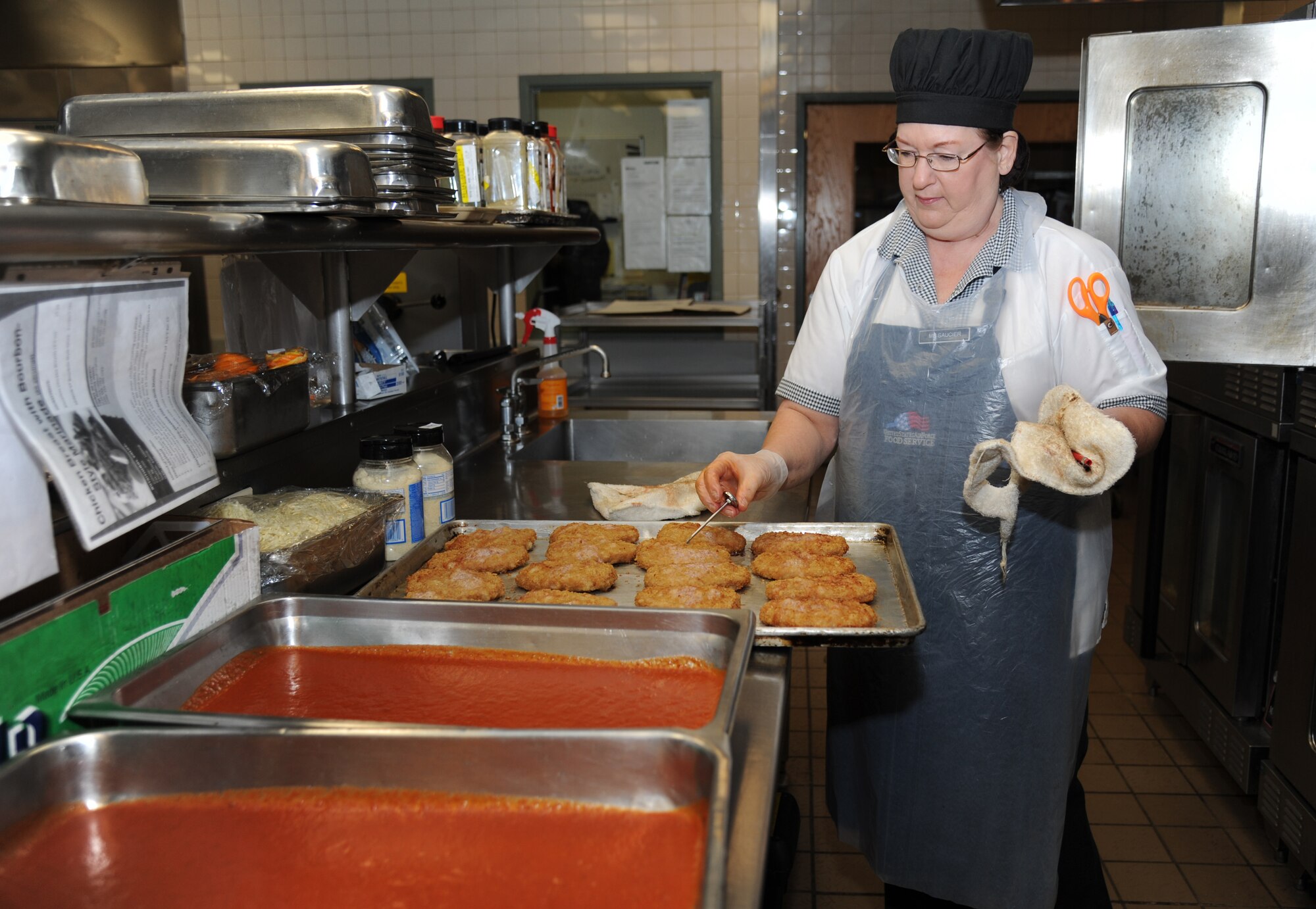Bonnie Saucier, cook, prepares veal parmesan at the Azalea Dining Facility Jan. 22, 2013, at Keesler Air Force Base, Miss.  The 81st Force Support Squadron food service operations accommodated a $1.25 million budget cut by shortening hours at the Live Oak Dining facility and expanding hours at Azalea and Magnolia dining halls.  (U.S. Air Force photo by Kemberly Groue)