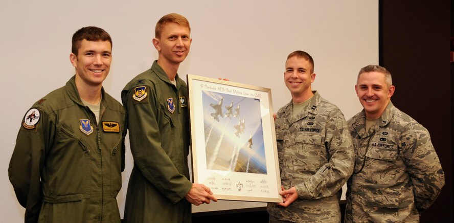 Maj. Warren Carroll, 11th Bomb Squadron, Capt. Joshua Yerk, 2nd Civil Engineer Squadron, and 1st Lt. Andrew Cooper, 2nd Munitions Squadron are awarded a plaque for excellence from the US Air Force Thunderbirds by Col. Reid Langdon, 2nd Bomb Wing vice commander, Barksdale Air Force Base, La., Jan. 23. Out of the many locations the Thunderbirds performed during the 2012, Barksdale was recognized as the top location for support they provided during the 2012 Defenders of Liberty Airshow. (U.S. Air Force photo/Airman 1st Class Andrew Moua)