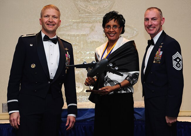 Colonel Darren Hartford, 437th Airlift Wing commander, and Chief Master Sgt. Larry Williams, 437th AW command chief, present the 437th AW Airlift Wing Civilian of the Year, Category One award to Faye Ellison from the 15th Airlift Squadron during the 437th AW Annual Awards Banquet held at the Charleston Club, Jan. 18, 2013, at Joint Base Charleston - Air Base, S.C. (U.S. Air Force photo/Staff Sgt. Rasheen Douglas)