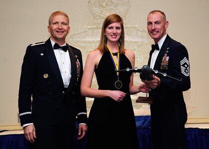 Colonel Darren Hartford, 437th Airlift Wing commander, and Chief Master Sgt. Larry Williams, 437th AW command chief, present the 437th AW Senior Grade Officer of the Year award to Rachel Boyd on behalf of her husband Capt. Adam Boyd from the 15th Airlift Squadron during the 437th AW Annual Awards Banquet held at the Charleston Club, Jan. 18, 2013, at Joint Base Charleston - Air Base, S.C. (U.S. Air Force photo/Staff Sgt. Rasheen Douglas)