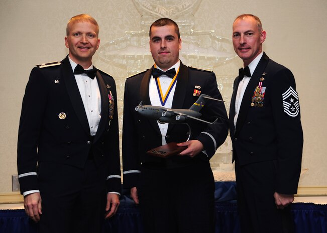 Colonel Darren Hartford, 437th Airlift Wing commander, and Chief Master Sgt. Larry Williams, 437th AW command chief, present the 437th AW Junior Grade Officer of the Year award to 2nd Lt. Jordan Passmore from the 437th APS at the 437th AW Annual Awards Banquet held at the Charleston Club, Jan. 18, 2013, at Joint Base Charleston - Air Base, S.C. (U.S. Air Force photo/Staff Sgt. Rasheen Douglas)