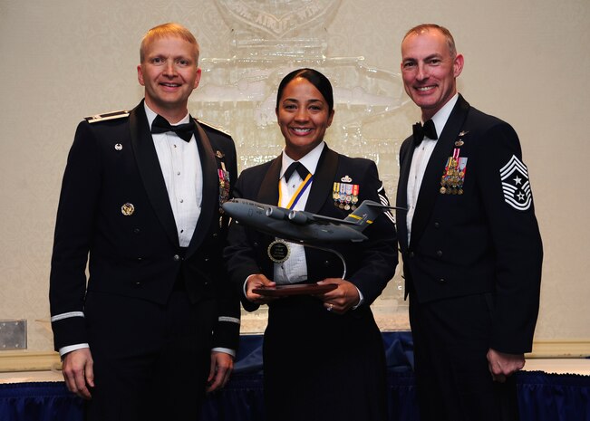 Colonel Darren Hartford, 437th Airlift Wing commander, and Chief Master Sgt. Larry Williams, 437th AW command chief, present the 437th AW First Sergeant of the Year award to Master Sgt. Jadirra Walls from the 437th Maintenance Squadron during the 437th AW Annual Awards Banquet held at the Charleston Club, Jan. 18, 2013, at Joint Base Charleston - Air Base, S.C. (U.S. Air Force photo/Staff Sgt. Rasheen Douglas)