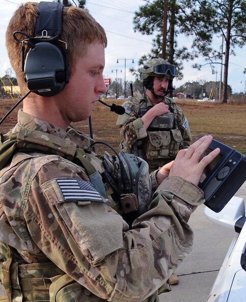 Senior Airman Allen Westfall, 7th Air Support Operations Squadron, Ft. Bliss, Texas, determines coordinates of their location as Staff Sgt. Michael McAndrew, 9 ASOS, Ft. Hood, Texas, speaks over radio with the pilot in an F-16 Fighting Falcon flying overhead in Leesville, La., Jan. 21. The two Joint Terminal Air Controllers, along with four other JTAC, participated in Green Flag East 13-03 as a Tactical Air Control Party assisting F-16s from Shaw Air Force Base, S.C. (U.S. Air Force photo/Staff Sgt. Amber Ashcraft)