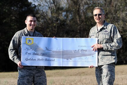 Col. Darren Hartford, 437th Airlift Wing commander, presents the "Golden Bolt Award” to Airman 1st Class Donald Kinlin  after the Foreign Object Debris walk Jan. 17, 2013, at Joint Base Charleston - Air Base, S.C. JB Charleston  brought he fun of treasure hunting into its FOD walk, by hiding a prized "Golden Bolt" along the flight line. By removing FOD from runways and flightlines, Airmen help save the Air Force millions of dollars in costly engine repairs and replacement every year. (Courtesy photo)