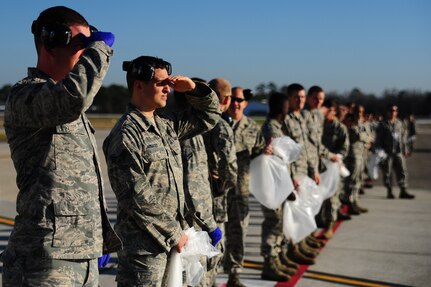 Joint Base Charleston Airmen equip and line up  to start the Foreign Object Debris walk Jan. 17, 2013, at JB Charleston - Air Base, S.C. By removing FOD from runways and flightlines, Airmen potentially help save the Air Force millions of dollars in costly engine repairs and replacement every year.  (U.S. Air Force photo/ Airman 1st Class Chacarra Walker)