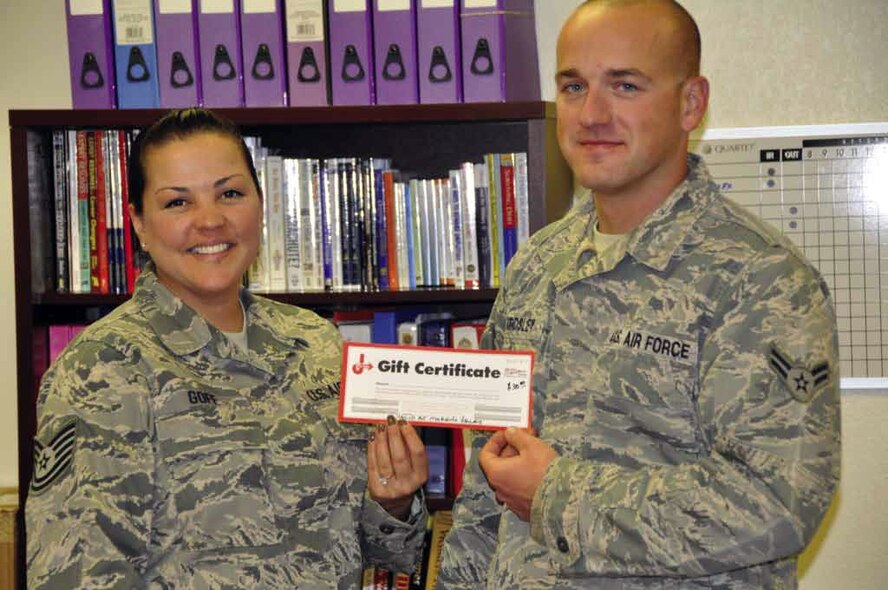 Tech. Sgt. Crystal Goff, March Airman & Family Readiness Center, hands Airman
1st Class Andrew Beardsley, 912th Air Refueling Squadron, a voucher under the
Car Care Because We Care program, Jan. 14. The program is designed to ease the
financial impact of deployments on Air Force families by providing a cash-equivalent
voucher for basic maintenance service on the member’s primary vehicle. (U.S. Air Force photo by Darnell Gardner)