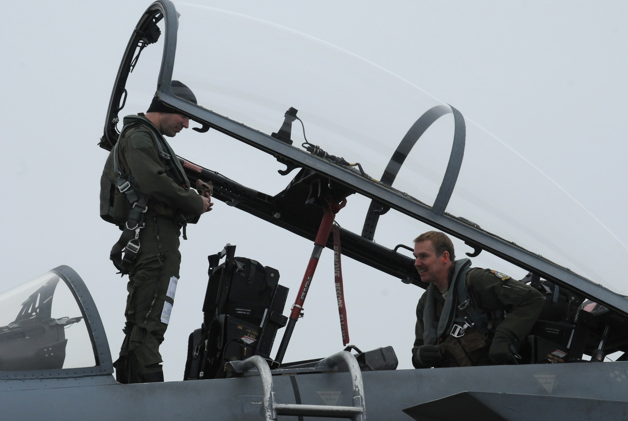 Capt. Dustin Edwards, 493rd Fighter Squadron pilot, and Chief Master Sgt. Christopher Powell, 100th Air Refueling Wing command chief from Cypress Fairbanks, Texas, prepare to disembark an F-15 Eagle aircraft after an incentive flight for Powell Jan. 18, 2013, at RAF Lakenheath, England. Powell earned the flight, which was delayed several days due to low visibility, for his outstanding service over a nearly 30-year Air Force career. (U.S. Air Force photo by Tech. Sgt. Neal X. Joiner/Released)
