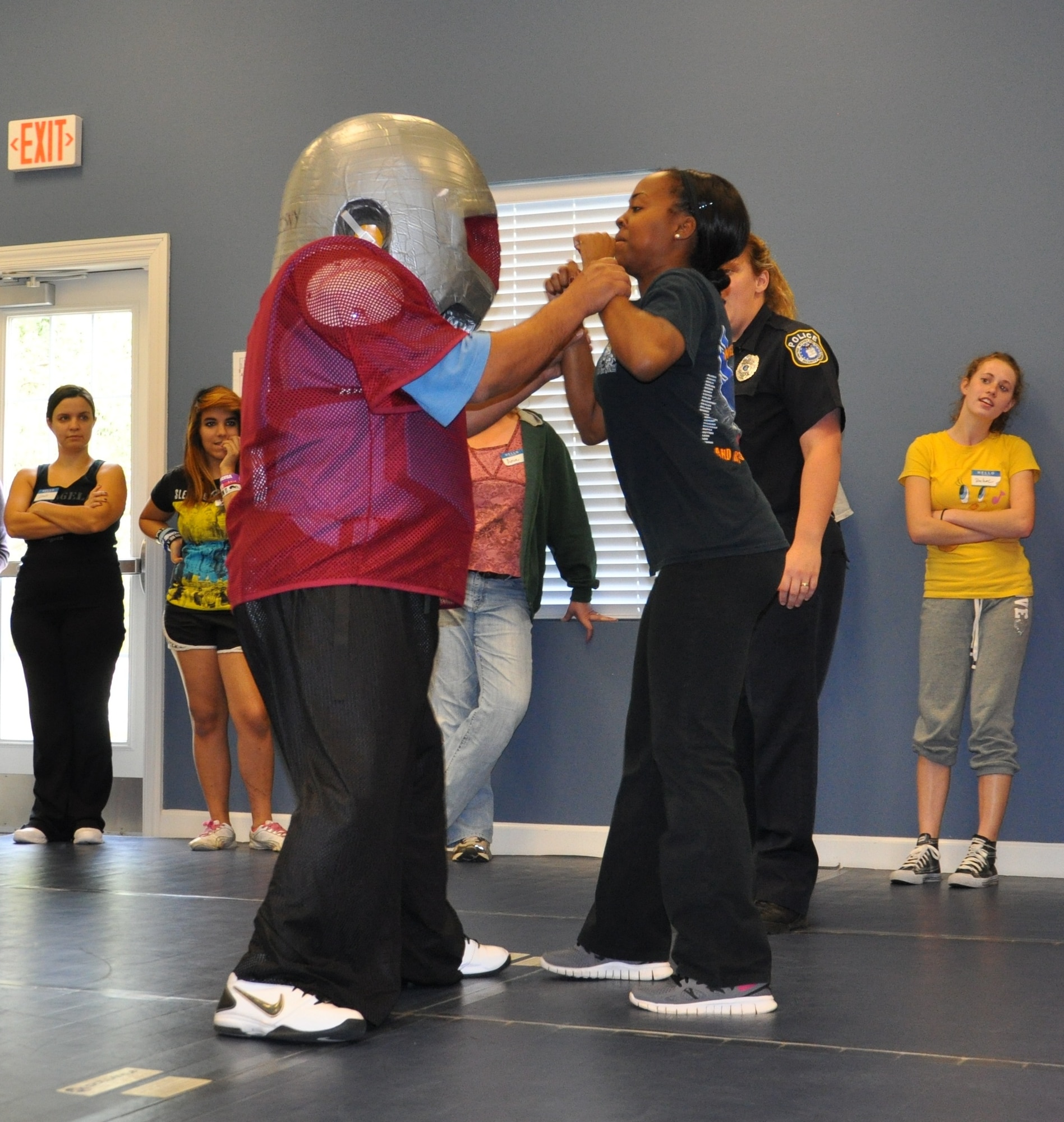 Corporal Juan Diaz, 325th Security Forces Squadron civilian police officer and Fear Adrenaline Stress Training class lead instructor, plays a ‘bad guy’ while suited in padding. Senior Airman Jalisa Sampson, 325th SFS member and F.A.S.T. instructor, shows the women how to break away from a possible attack during 2013’s first F.A.S.T. class Jan. 19 at the Balfour Beatty Community Center. (U.S. Air Force photo by Senior Airman Christopher Reel)
