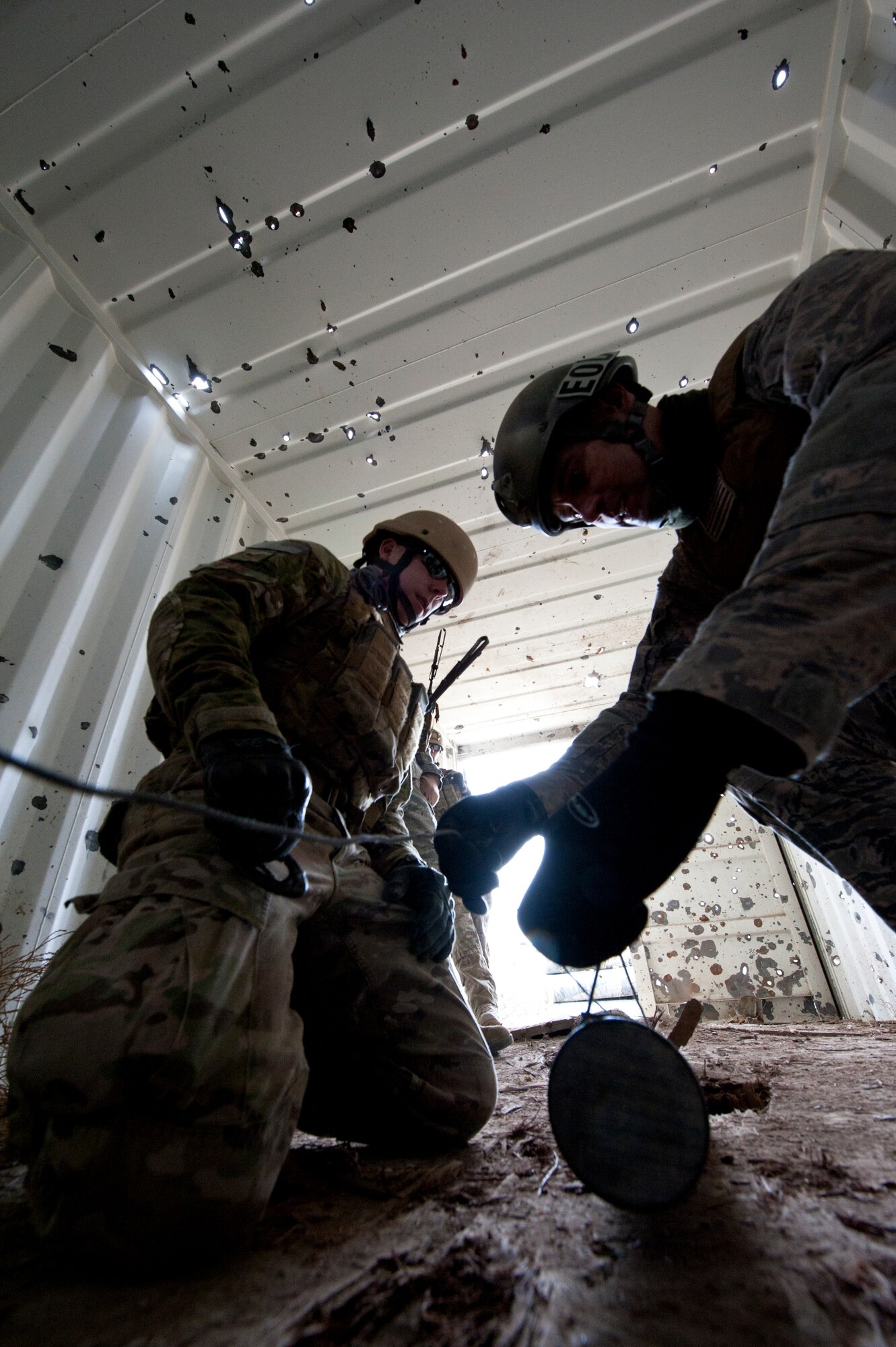 FORT CARSON, Colo. -- Master Sgt. Paul Horton, 21st Civil Engineer Squadron EOD flight chief demonstrates how to secure unexploded ordnance with a 'hook and line' kit during a training exercise Jan. 10 at Fort Carson. Exercises like this are designed to expose Airmen to the physical and mental fatigue experienced while deployed. The Airmen from the 21st EOD flight use the training learned in these exercises to fulfill their role as a defensive force at home and while deployed. (U.S. Air Force photo/Staff Sgt. J. Aaron Breeden)