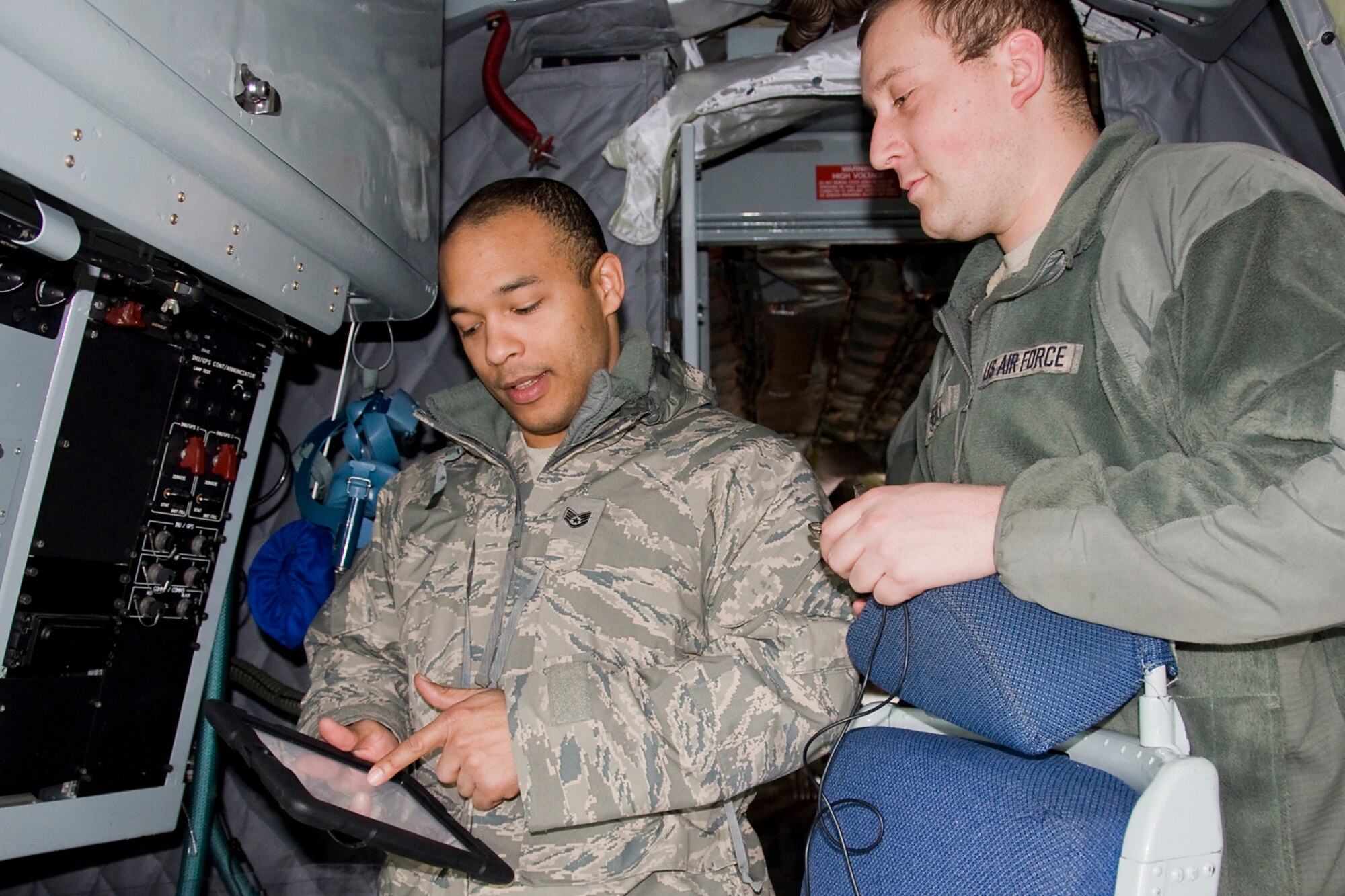 GRISSOM AIR RESERVE BASE, Ind. -- Staff Sgt Gregory Lee and Senior Airman Matthew Steele, both  434th Aircraft Maintenance Squadron electrical and environmental systems technicians, use a tablet device while tracking down a wire causing intermittent failure issues with a KC-135's the fuel dump actuator in the refueling boom here recently. The maintainers had to locate a single failure point along the wire, which runs from the tail of the aircraft to the cockpit. (U.S. Air Force photo/Maj. Kelly Howard)
