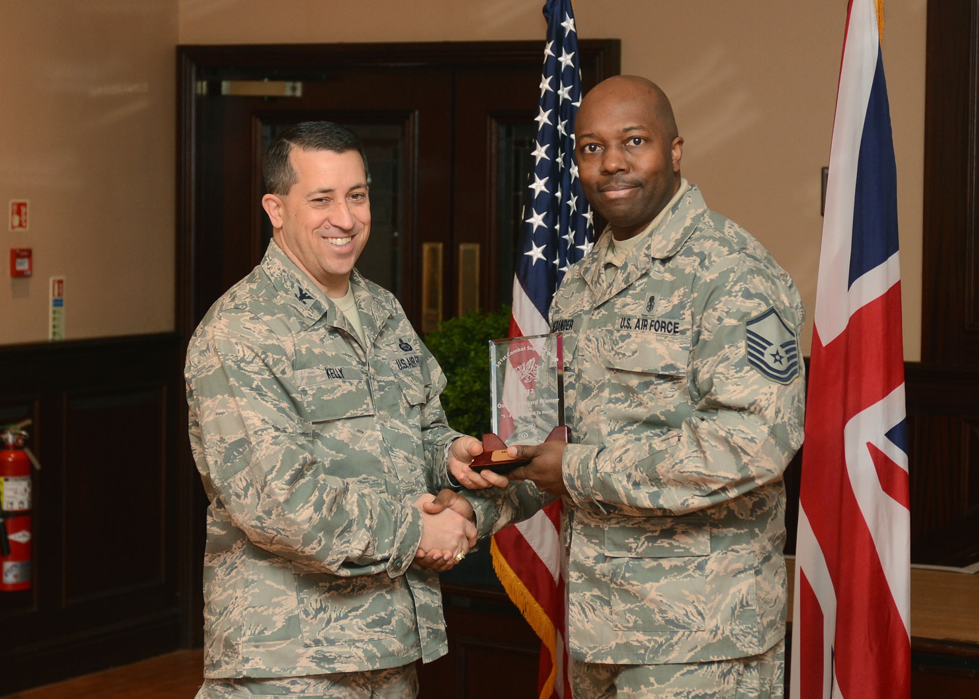 RAF MENWITH HILL, United Kingdom - Col. Brian Kelly, 501st Combat Support Wing commander, presents Master Sgt. Shawn Alexander, 421st Air Base Squadron, with an award for being named the 501st CSW Senior Non-Commissioned Officer for the fourth quarter Jan. 18. (U.S. Air Force photo by Staff Sgt. Debbie Lockhart)