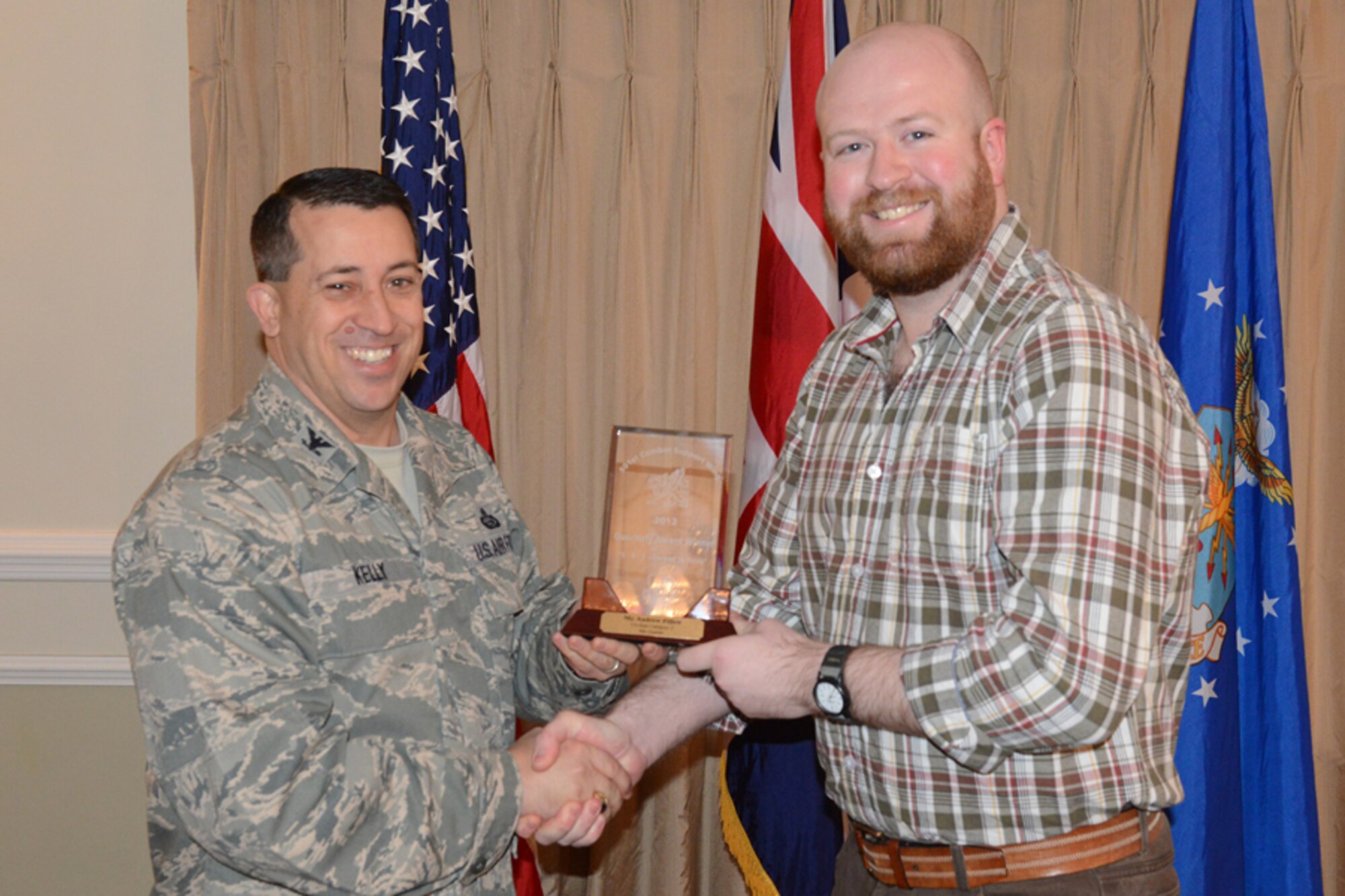 RAF ALCONBURY, United Kingdom - Col. Brian Kelly, 501st Combat Support Wing commander, presents Andrew Pillow, 501st CSW, with an award for being named the 501st CSW Civilian Category II for the fourth quarter Jan. 16. (U.S. Air Force photo by Tech. Sgt. Chrissy Best)