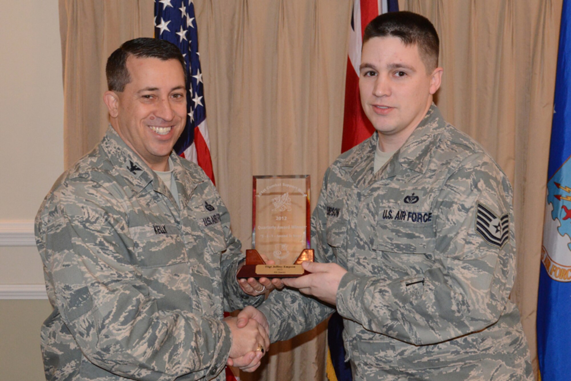 RAF ALCONBURY, United Kingdom - Col. Brian Kelly, 501st Combat Support Wing commander, presents Tech. Sgt. Jeffrey Empson, 501st CSW, with an award for being named the 501st CSW Non-Commissioned Officer for the fourth quarter Jan. 16. (U.S. Air Force illustration by Tech. Sgt. Chrissy Best)