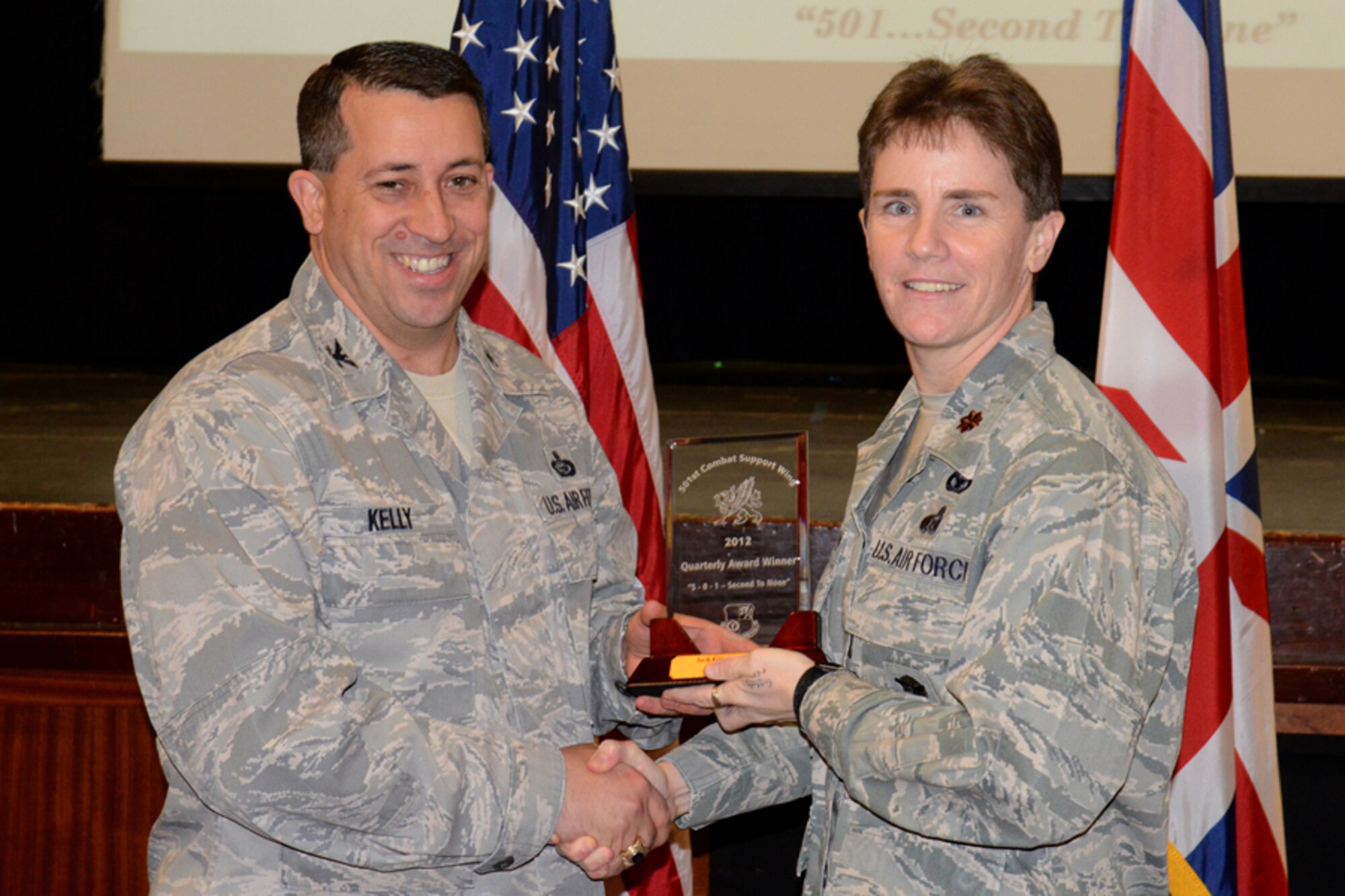 RAF CROUGHTON, United Kingdom – Maj. Kelli Green, 422nd Security Forces Squadron commander, accepts the 501st CSW Airman award for the fourth quarter from Col. Brian Kelly, 501st Combat Support Wing commander, on behalf of Senior Airman Garrett Christ, 422nd Air Base Group, Jan. 14. (U.S. Air Force photo by Tech. Sgt. Chrissy Best)
