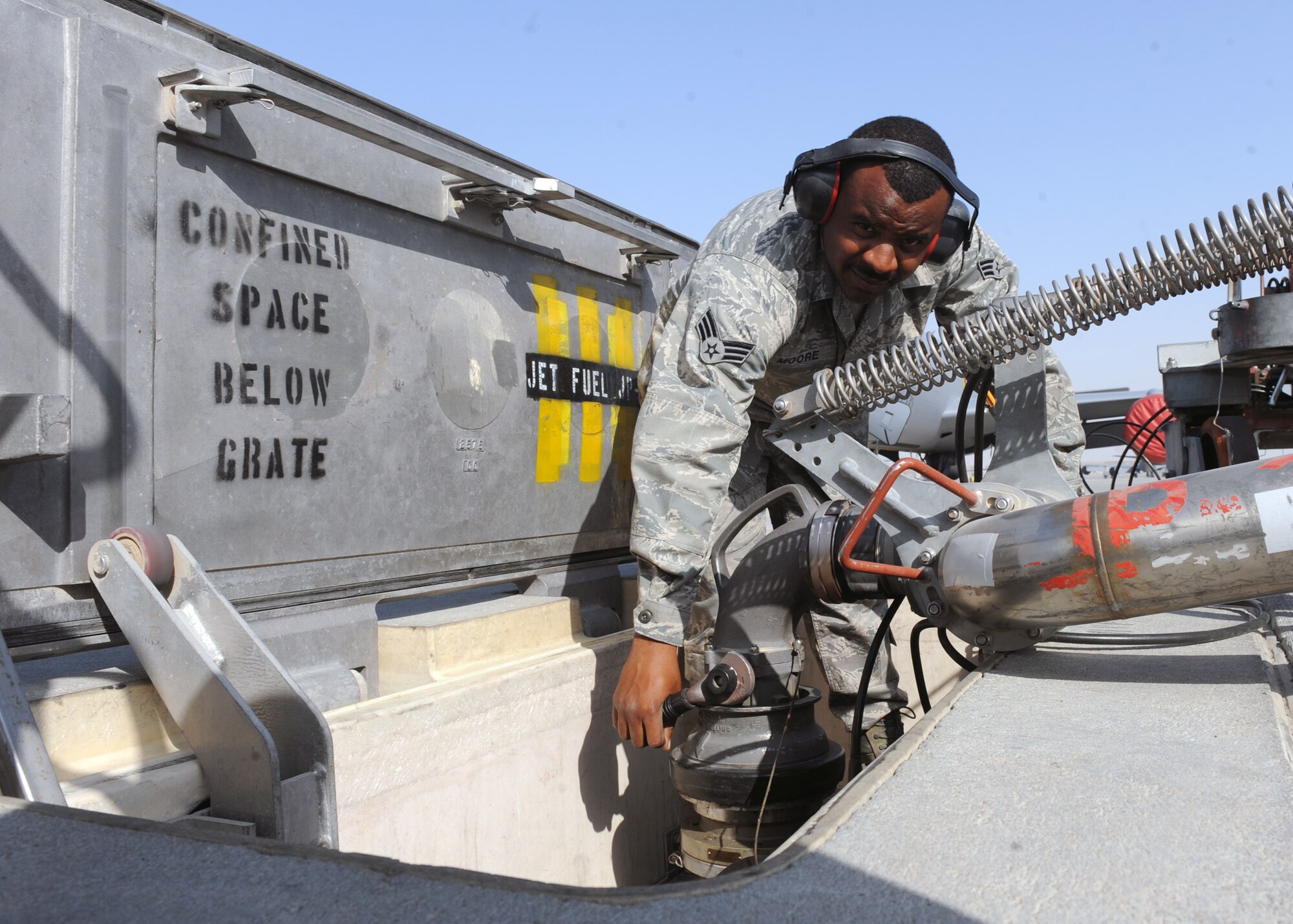 SOUTHWEST ASIA - Senior Airman Quincy Moore, 379th Expeditionary Logistics Readiness Squadron fuels distribution operator, opens the hydrant adapter in order to fill up his fuel truck on the flight line Jan. 22. Each truck can hold approximately 6,000 gallons of JP-8. Moore is deployed from Pope Field, N.C. (U.S. Air Force photo/Senior Airman Joel Mease)