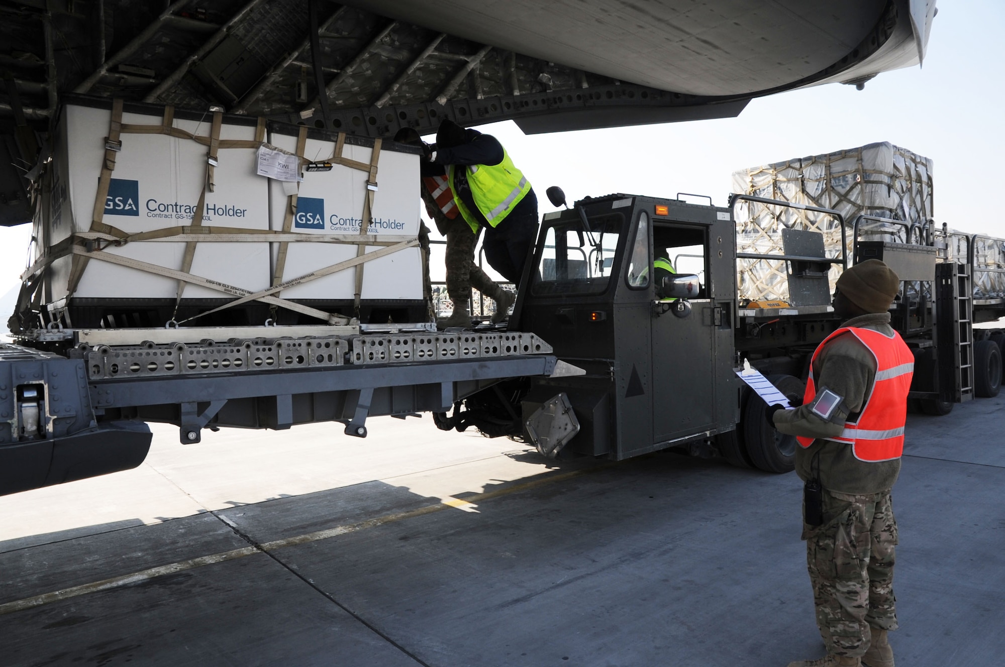 Tech. Sgt. Curtis Priester, 455th Expeditionary Aerial Port Squadron safety alternate, monitors the loading of cargo onto a C-17 Globemaster III on Bagram Airfield, Afghanistan, Jan. 21, 2013. Priester is participating in the 455th EAPS "Stripes on the Line" program where NCOs and Senior NCOs act as an additional set of eyes to spot any hazards during operations. (U.S. Air Force photo/Staff Sgt. David Dobrydney)