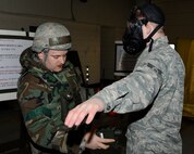 Senior Airman Jacob Kerschner, left, 8th Civil Engineer Squadron firefighter, checks Senior Airman Kevin O’Neil, 8th Operation Support Squadron, for any sign of during exercise Beverly Midnight 13-1 at Kunsan Air Base, Republic of Korea, Jan. 18, 2013.  O’Neil became contaminated after a post-attack reconnaissance sweep around his facility. (U.S. Air Force photo by Senior Airman Marcus Morris/Released)  