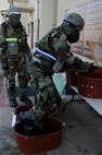 Senior Airmen Kevin O’Neil, right,  and Justin Holbrook, 8th 8th Operations Support Squadron, decontaminate themselves before re-entering their building during exercise Beverly Midnight 13-1 at Kunsan Air Base, Republic of Korea, Jan. 18, 2013. The post-attack reconnaissance  sweep allowed the team to find that their building and surrounding area had become contaminated. (U.S. Air Force photo by Senior Airman Marcus Morris/Released)  