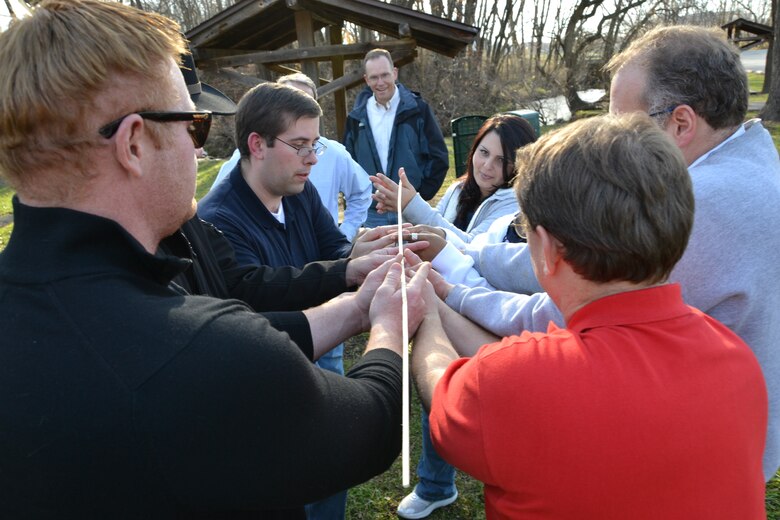 A Tier II team attempts to bring a “helium stick” to the ground through use of leaderships skills and teamwork. (Photo by Kristin Hoelen)
