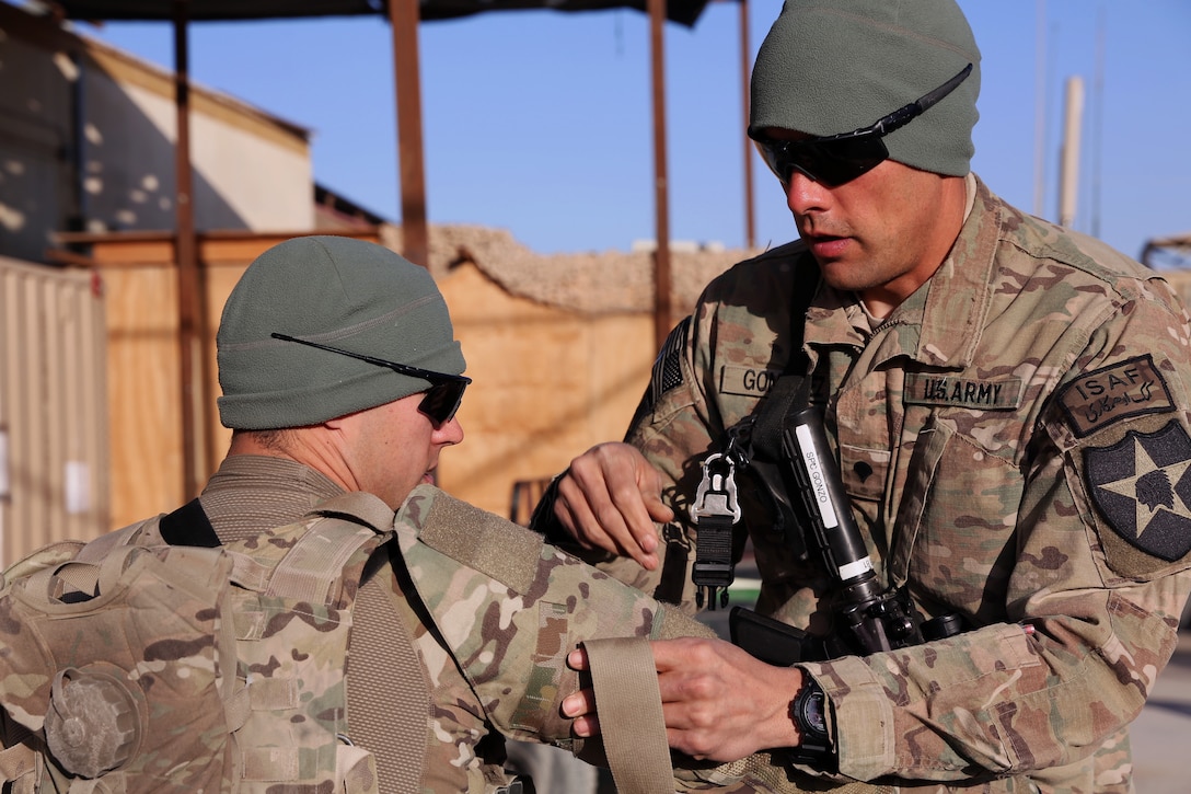 U.S. Army Spc. Joseph Gonzalez, right, assists U.S. Army Spc. Joseph ...