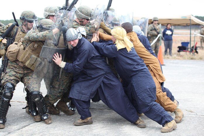 Marines with Easy Company, Black Sea Rotational Force 13, hold back Marine role players that are attacking the mock embassy. Marines and sailors with Easy Company, and the 2013 iteration of BSRF conducted their first embassy reinforcement mission rehearsal exercise the week of January 7. 
