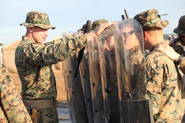 Staff Sgt. Orlendo Saunders a platoon sergeant with Easy Company, Black Sea Rotational Force 13, inspects the Marines gear, and shows them where they should hold their shields in case of a riot. Marines and sailors with Easy Company, and the 2013 iteration of BSRF conducted their first embassy reinforcement mission rehearsal exercise the week of January 7.