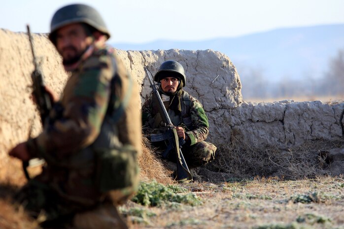 A soldier in the Afghan National Army takes cover behind a wall while receiving enemy fire during Operation New Hope, Kajaki, Afghanistan, Jan. 16. During the operation, the ANA partnered with the Afghan National Civil Order Police and the Afghan Uniform Police in an effort to bring peace, stability and increase the Government of the Islamic Republic of Afghanistan’s influence in the area. Afghan National Security Forces localized their efforts to Kajaki Sofala, part of the southern green zone in Kajaki, and a known insurgent hotbed in the district.