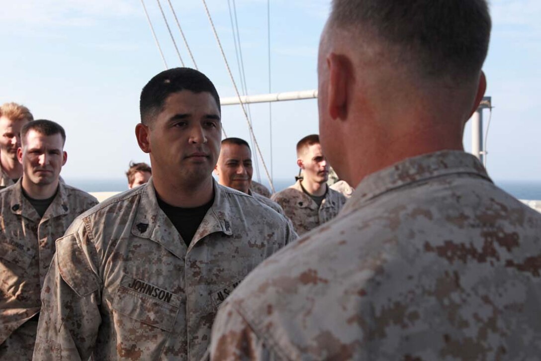 Sgt. Jacob M. Johnson, imagery analyst, Command Element, 15th Marine Expeditionary Unit, re-enlists under the authority of Col. Scott D. Campbell, the unitâ€™s commanding officer, while aboard the USS Peleliu, Jan. 14. The 15th MEU is deployed as part of the Peleliu Amphibious Ready Group as a U.S. Central Command theater reserve force, providing support for maritime security operations and theater security cooperation efforts in the U.S. 5th Fleet area of responsibility. Johnson, 28, is from Whittier, Calif. (U.S. Marine Corps photo by Cpl. John Robbart III)