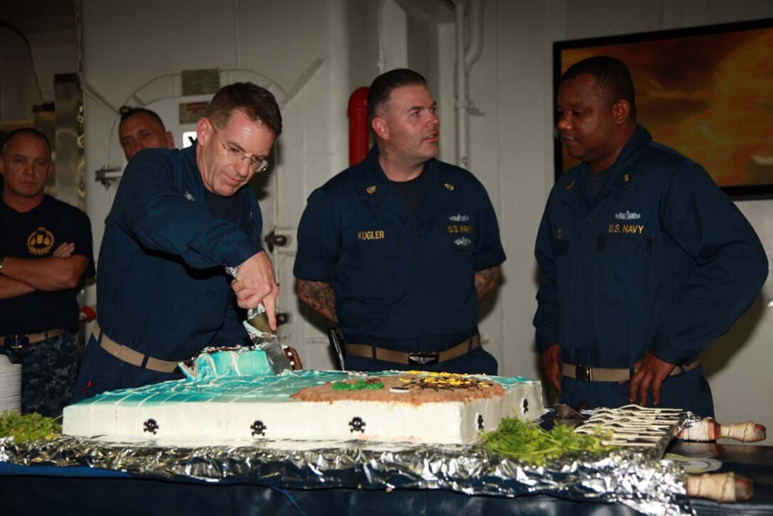 Navy Capt. John Deehr, commanding officer, USS Peleliu, cuts a cake to commemorate the half-way point of the 15th MEU and Peleliu Amphibious Ready Group deployment, Jan. 17. To celebrate the event, the shipâ€™s food services division made a special meal for the embarked service members that included steak, king crab legs and cake. The 15th MEU is deployed as part of the Peleliu ARG as a U.S. Central Command theater reserve force, providing support for maritime security operations and theater security cooperation efforts in the U.S. 5th Fleet area of responsibility. (U.S. Marine Corps photo by Cpl. John Robbart III)