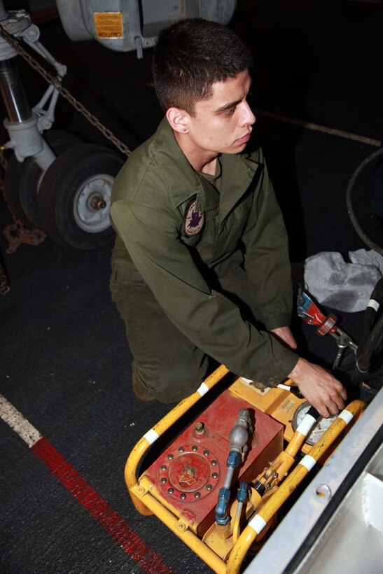 Lance Cpl. Daniel M. Jimenez, T-64 engine mechanic, Marine Medium Helicopter Squadron 364 (Rein.), 15th Marine Expeditionary Unit, pumps oil from a T-64 jet engine into a fuel control for engine preservation in the hangar bay of the USS Peleliu, Jan. 18. The 15th MEU is deployed as part of the Peleliu Amphibious Ready Group as a U.S. Central Command theater reserve force, providing support for maritime security operations and theater security cooperation efforts in the U.S. 5th Fleet area of responsibility. Jimenez, 21, is from Soledad, Calif. (U.S. Marine Corps photo by Cpl. John Robbart III)