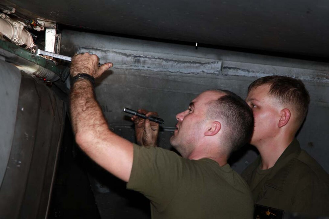 Corporal Dustin W. Cawley (left), and Lance Cpl. Jesse S. Hager, both AV-8B airframes mechanics with Marine Medium Helicopter Squadron 364 (Rein.), 15th Marine Expeditionary Unit, perform routine maintenance on an AV-8B Harrier in the hangar bay of the USS Peleliu, Jan. 18. The 15th MEU is deployed as part of the Peleliu Amphibious Ready Group as a U.S. Central Command theater reserve force, providing support for maritime security operations and theater security cooperation efforts in the U.S. 5th Fleet area of responsibility. Cawley, 25, is from Folkston, Ga., and Hager, 23, is from Ionia, Mich. (U.S. Marine Corps photo by Cpl. John Robbart III)