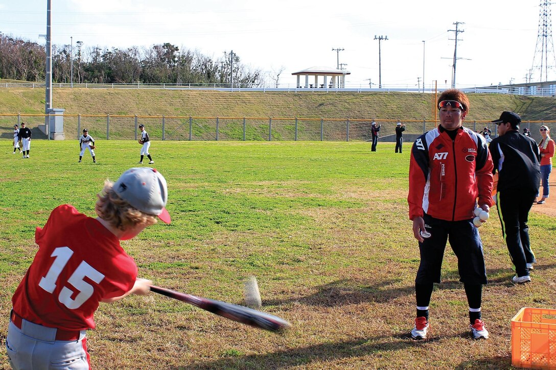 Shota Ishimine watches as a youth baseball player hits a ball during a baseball clinic Jan. 19 at Camp Hansen. Ishimine is a professional baseball player with the Chiba Lotte Marines.