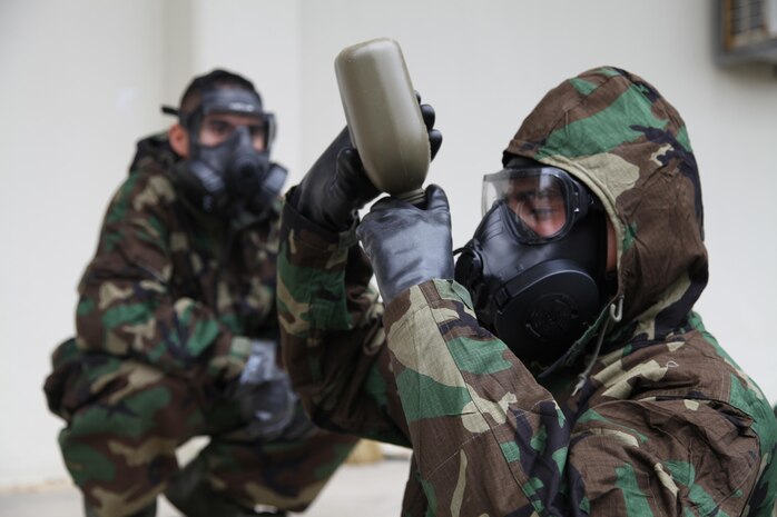 Cpl. Devon A. Luevano demonstrates the proper way to hydrate while wearing mission oriented protective posture gear during a communications exercise Jan. 16 at Camp Foster. During the exercise, the Marines wore MOPP gear while performing their day-to-day tasks, ranging from radio checks to communications site setup. Luevano is a field wireman with Combat Logistics Battalion 4, Combat Logistics Regiment 3, 3rd Marine Logistics Group, III Marine Expeditionary Force.
