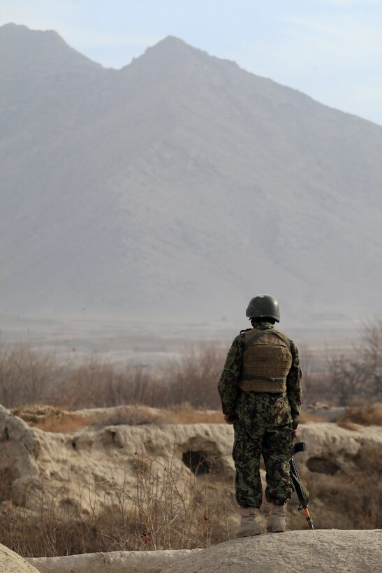 An Afghan National Army soldier stands watch on a roof during Operation New Hope, Kajaki, Afghanistan, Jan. 18. During the three-day operation, more than 100 ANA soldiers along with various Afghan National Security Forces elements cleared weapons caches, improvised explosive devices and enemy fighting positions from the area. Accompanying the ANA were 18 Marine advisors providing call for fires and tactical input when needed. Afghan National Security Forces localized their efforts to Kajaki Sofala, part of the southern green zone in Kajaki and a known insurgent hotbed in the district.
