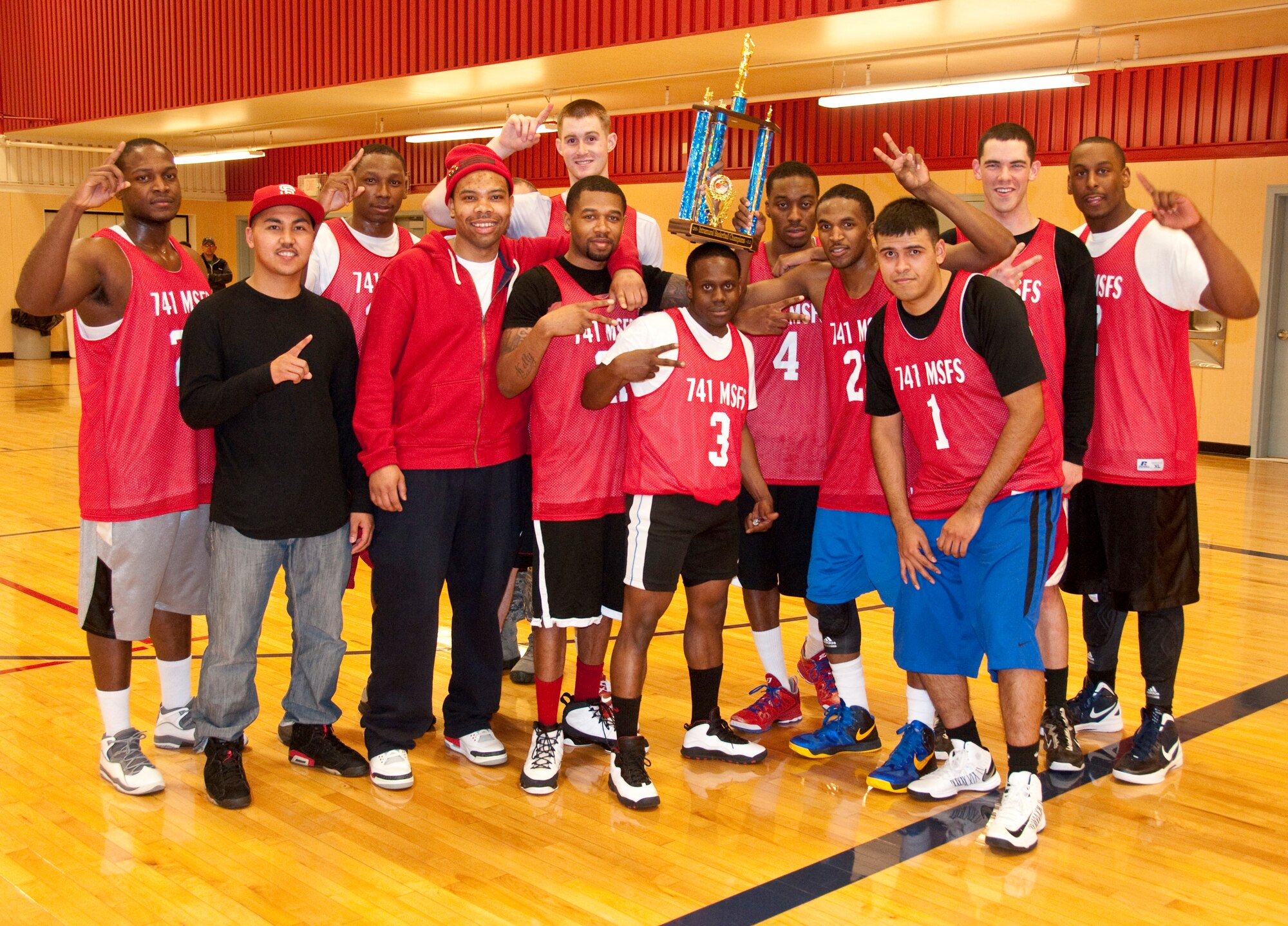 Members of the 741st Missile Security Forces Squadron intramural basketball team pose with their trophy after winning the league championship on Jan. 18.  They beat the 819th RED HORSE Squadron team with a final score of 58 to 45.  Pictured from left to right are Airman 1st Class Angelo Harris Jr., Airman 1st Class Collin Reber, Senior Airman Juan Valles, Airman 1st Class Hakim Ameen, Airman 1st Class Christopher Frederick, Senior Airman Joseph Hickson, Kelly Grogan, Airman 1st Class John Robertson, Airman 1st Class Richard Lotterer Jr., Staff Sgt. Eric McGowan, Staff Sgt. Rey Rin (coach), and Staff Sgt. Kelvin Burns. (courtesy photo)