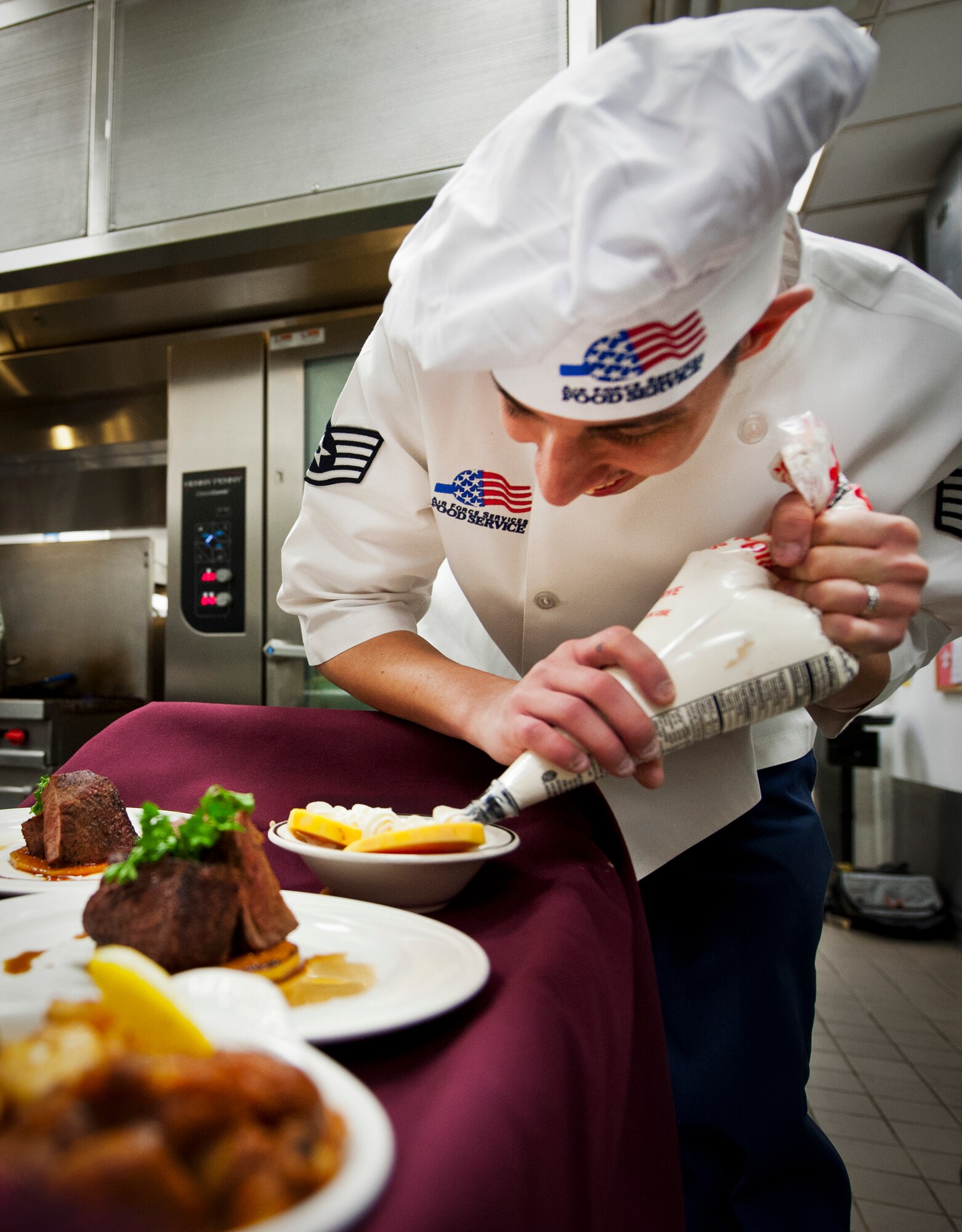 Staff Sgt. Orlando Piedrahita, of the 96th Force Support Squadron, puts the finishing touches on his dessert during the “Cooking with the Stars” competition Jan. 22 at Eglin Air Force Base, Fla.  Cooks from the 96th FSS teamed up with base leadership to compete in the cooking contest.  The three teams had to create three dishes each in an hour and a half and include a secret ingredient in every entrée.  (U.S. Air Force photo/Samuel King Jr.)