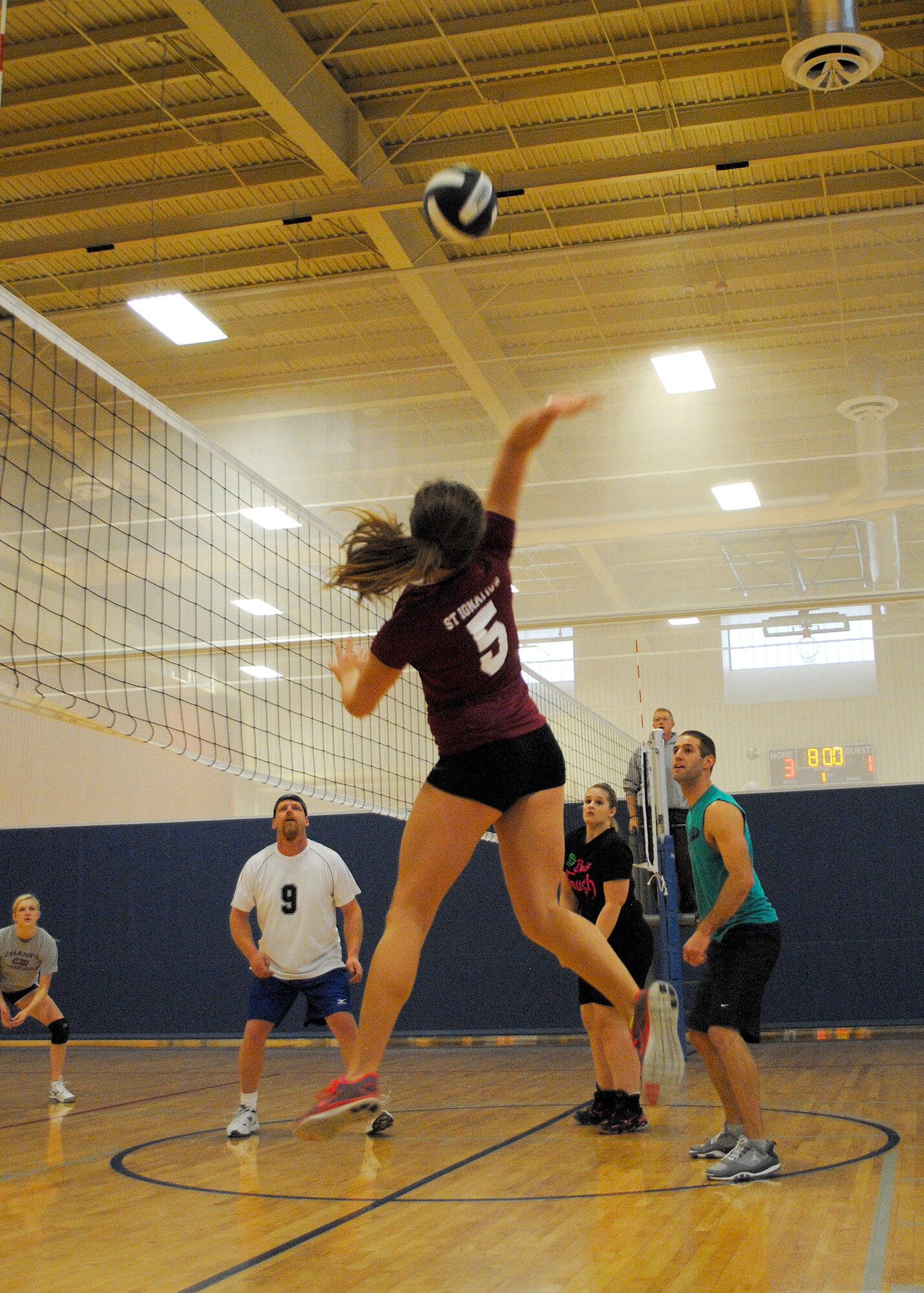 Ashley Courville, “Grandpa’s Clothes” team member, jumps to spike a ball during an elimination game at the tournament Jan. 19.  Participants received a free lunch during the two-day tournament and also had a chance to purchase T-shirts from the event.  (U.S. Air Force photo/Senior Airman Cortney Paxton)