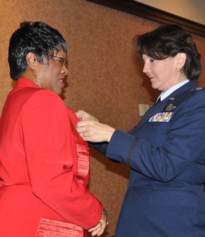 TRAVIS AIR FORCE BASE, Calif. -- Col. (sel) Jeanine McAnaney pins the commanders pin on her new Honorary Commander, Mrs. Brenda Knight, at the 2013 Induction CeremonyJan. 11, at Travis AFB. McAnaney commands the Reserve's 70th Air Refueling Squadron and is a KC-10 pilot. Knight, a military mother, is the founder and event planner of BK Ladies in Red, a women's empowerment group that provides motivation, education and inspiration to women age 55+, and is a Trustee for Napa Valley College. About 20 of her "ladies in red" attended the induction to celebrate her new post. (U.S. Air Force  photo/Senior Master Sgt. Ellen Hatfield) 