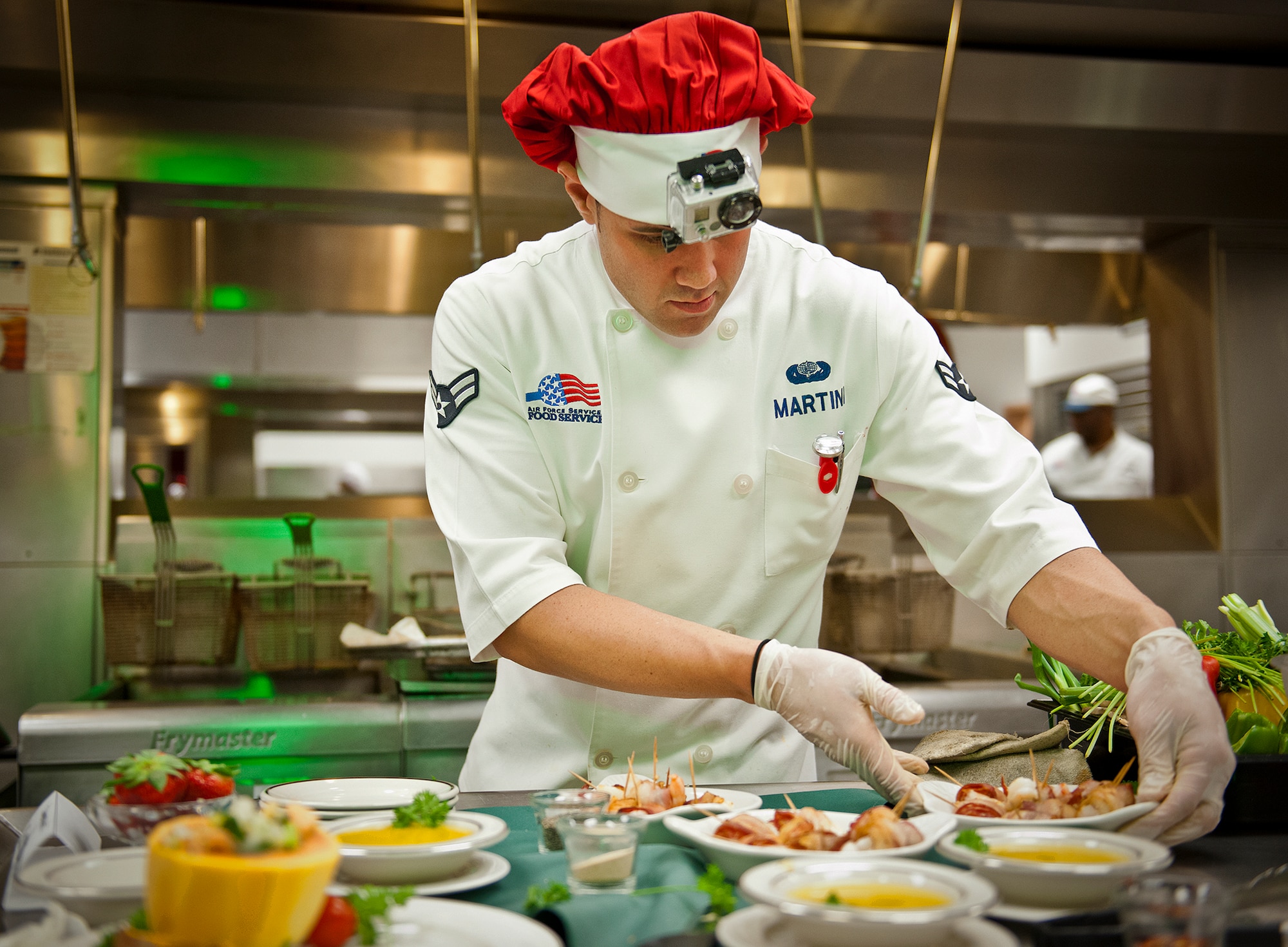 Airman 1st Class Giancarlo Martini, of the 96th Force Support Squadron, arranges his entrees before taking them to the judges at the “Cooking with the Stars” competition Jan. 22 at Eglin Air Force Base, Fla.  Base leadership teamed up with cooks from the 96th Force Support Squadron to compete in the cooking contest.  The three teams had to create three dishes each in an hour and a half and include a secret ingredient in every entrée.  Martini and his teammate, Lt. Col. Jason Delamater, the 96th FSS commander, won the contest with bacon-wrapped shrimp, ceviche, and papaya cake.  (U.S. Air Force photo/Samuel King Jr.)
