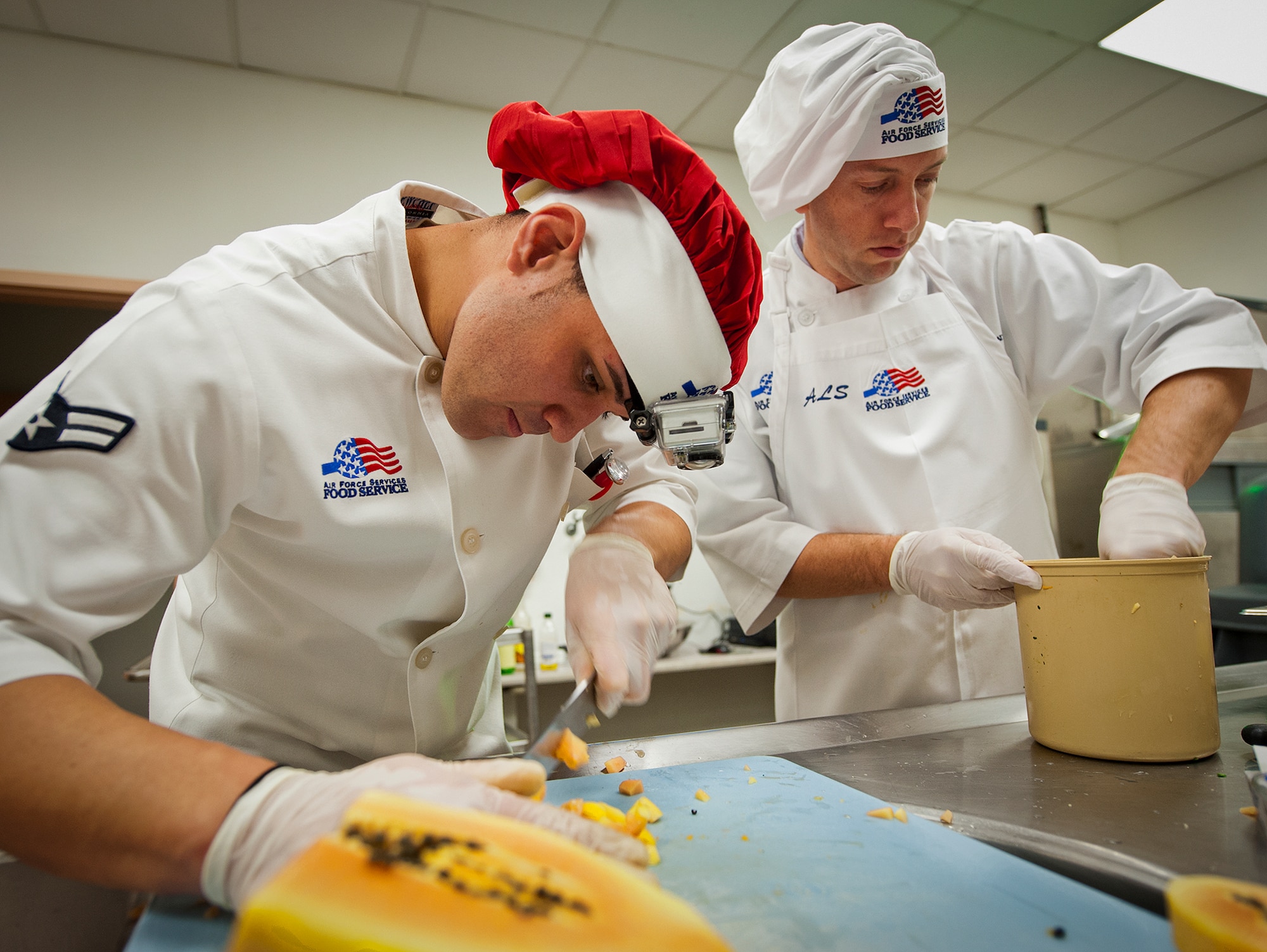 Airman 1st Class Giancarlo Martini and Lt. Col. Jason Delamater, of the 96th Force Support Squadron prepare their entree during the “Cooking with the Stars” competition Jan. 22 at Eglin Air Force Base, Fla.  Cooks from the 96th FSS teamed up with base leadership to compete in the cooking contest.  The three teams had to create three dishes each in an hour and a half and include a secret ingredient in every entrée.  Martini and Delamater won the contest with bacon-wrapped shrimp, ceviche and papaya cake.  (U.S. Air Force photo/Samuel King Jr.)