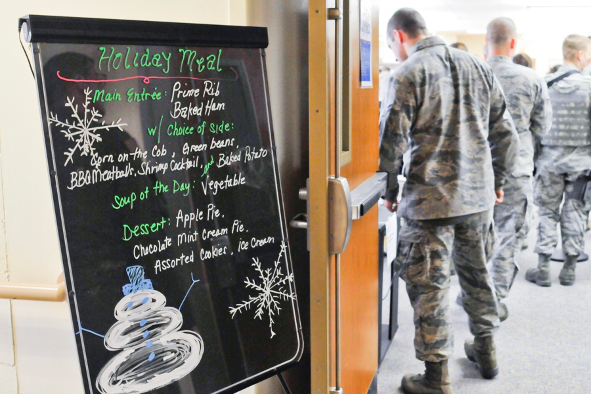 Airmen from the 182nd Airlift Wing, Peoria, Ill., stand in line to receive their holiday meal in the dining facility. Services personnel prepared a special menu for the holiday season for their fellow airmen. (U.S. Air Force photo by Master Sgt. Scott Thompson) (released)