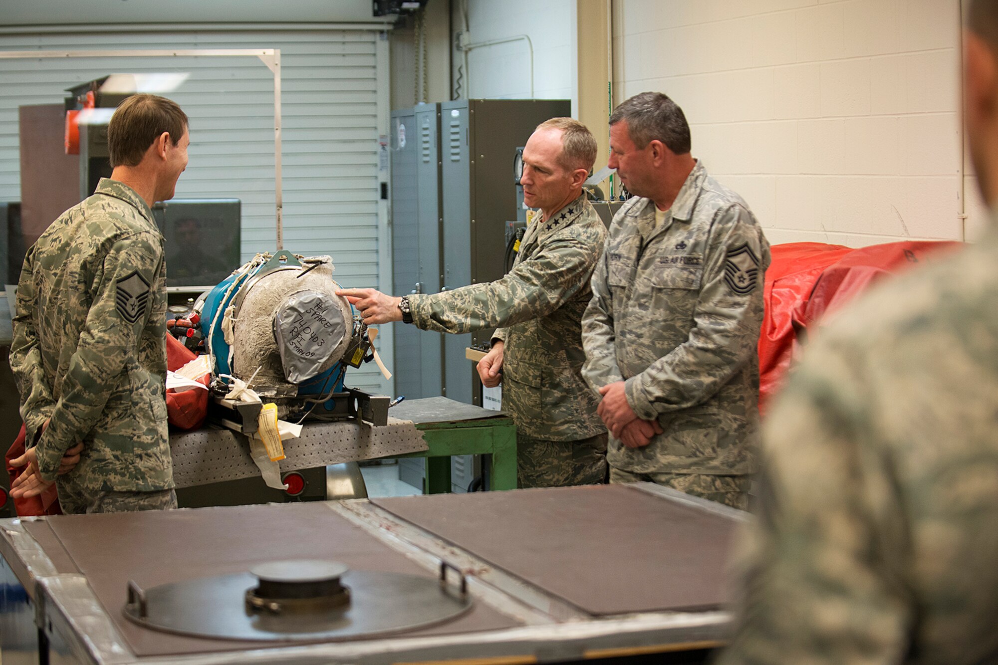 U.S. Air Force Gen. Michael Hostage takes a look at an Auxiliary Power Unit (APU) used in the A-10 Thunderbolt II during a tour given by Master Sgt. William George and Senior Master Sgt. Alan Horn, Jan. 23, 2013, Barksdale Air Force Base, La. George (left), assigned to the 917th Maintenance Squadron A-10 Engine Regional Repair Center, talked about maintenance procedures on the APU and ways to cuts costs. (U.S. Air Force photo by Master Sgt. Greg Steele/Released)