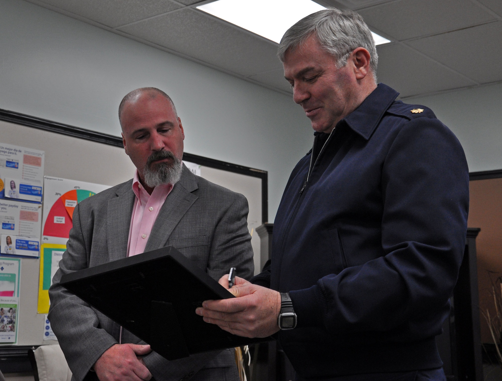 John Peasley, left, prepares to accept the Statement of Support for the Guard and Reserve Jan. 23 from Maj. Ray Schierhoff. 446th Secruity Forces Squadron commander. Schierhoff has just presented Peasley with an Employee Support of the Guard and Reserve Patriot Award. (U.S. Air Force Photo/Airman 1st Class Madelyn McCullough)
