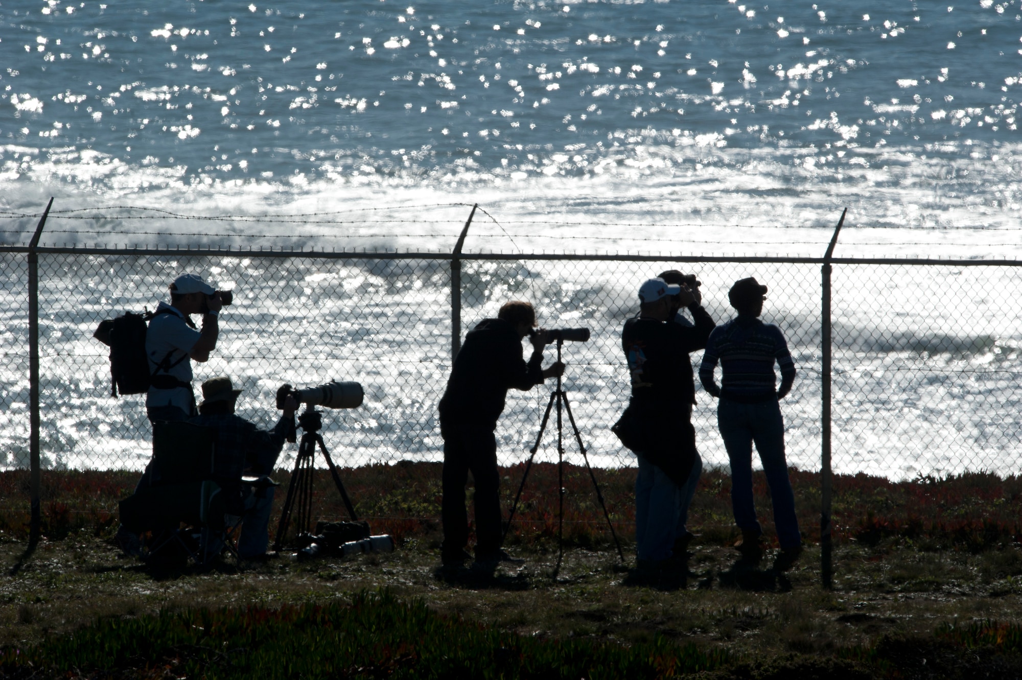 HALF MOON BAY, Calif. – Media line up along the fence of Pillar Point Air Force Tracking Station to get a better view of the 2013 Mavericks Invitational here Sunday, Jan. 20, 2013. Mavericks are world-renowned big wave breaks one and a half miles off the California coastline with waves cresting up to 50 feet, which attract the attention of 24 surfers near and far. (U.S. Air Force photo/Senior Airman Lael Huss)