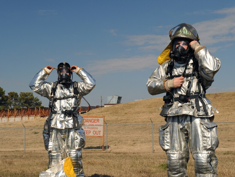 Airmen 1st Class Juan Rosario and Xazier Bailey, 2nd Civil Engineer Squadron firefighters, don their fire proximity suits on Barksdale Air Force Base, La., Jan. 23. The fire proximity suit is used specifically for aircraft fires and protects the firefighter from thermal radiation. Firefighters who deal with aircraft fires wear fire proximity suits to protect themselves from temperatures that can reach up to 2,000 degrees Fahrenheit. (U.S. Air Force photo/Airman 1st Class Benjamin Gonsier)