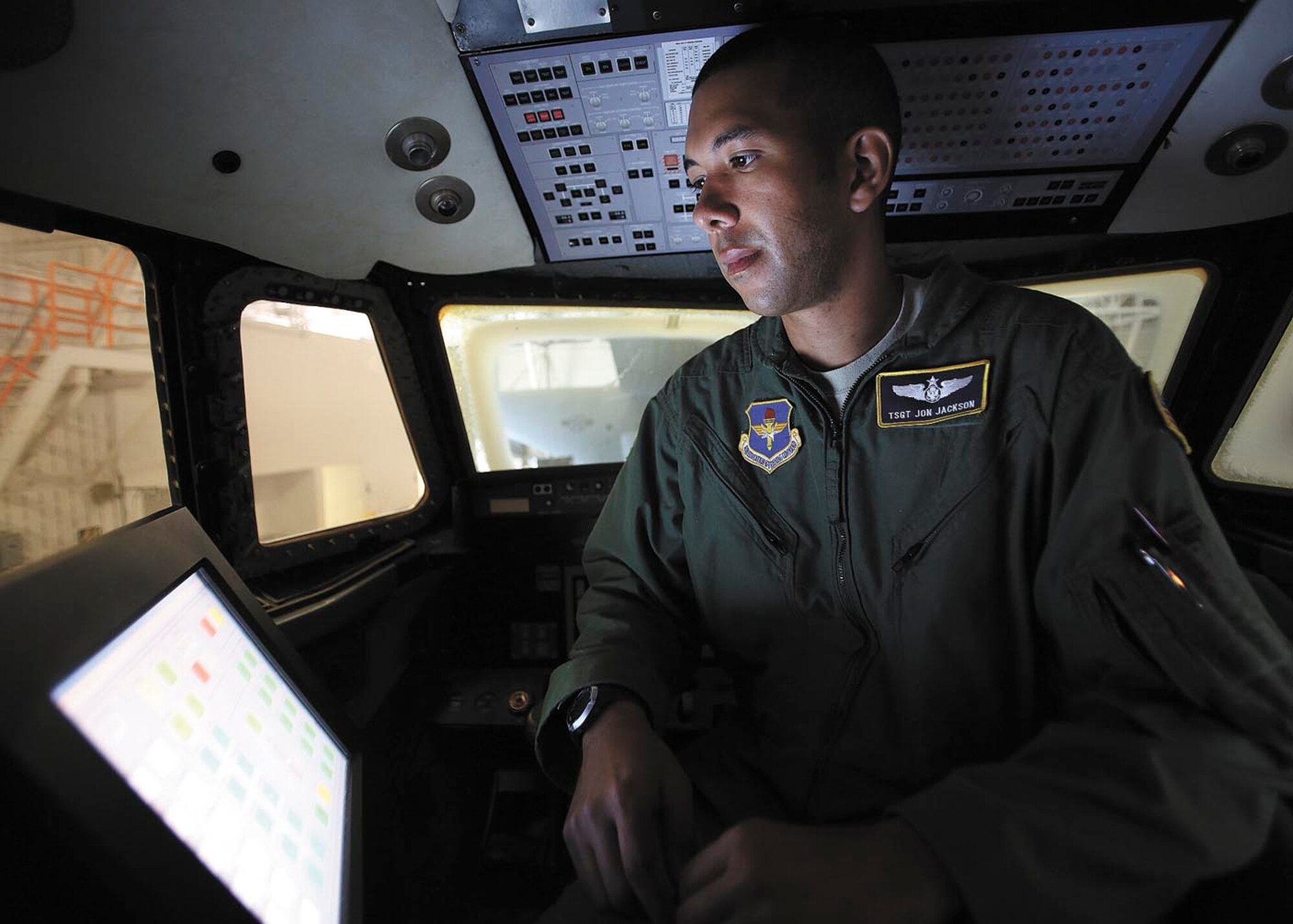 Technical Sgt. Jon Jackson evaluates students' mock evacuation procedures from the trainer aircraft, nicknamed "Speckled Trout," from the flight deck. Jackson is an instructor with the Basic Flight Attendant Course at JBSA-Lackland. (Photo by Robbin Cresswell)