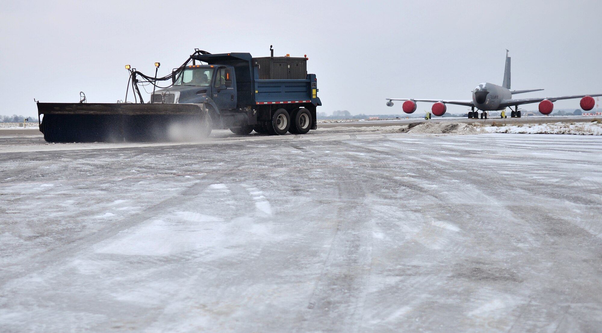 Members from the 100th CES pavements and equipment flight remove snow on the flightline Jan. 23, 2013, at RAF Mildenhall, England. Personnel from various squadrons and shops stood by to ensure the aircraft successfully launched after the base received heavy snow. (U.S. Air Force photo by Senior Airman Jerilyn Quintanilla/Released)  